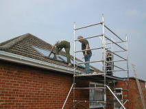 fitting solar hot water panels to a roof; a scaffold tower is essential