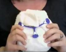 shaped nappy folded and fastened with a 'nappy-nippa'