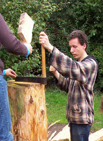 splitting a log with a froe and a wooden mallet