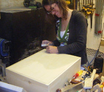 sanding a cabinet by hand with 120 grit aluminium oxide paper and sanding block