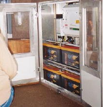 a cupboard containing 4 leisure batteries and an inverter on a vehicle with 12 x 80-watt pv panels on the roof