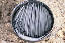 A biscuit tin of twigs for making artists' charcoal: before and after
