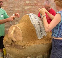Covering a dome of damp sand (with wooden door attached)