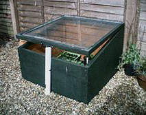 a cold frame being propped open further and further until the seedlings are hardened off enough to plant outside
