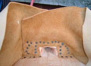 Both ends of leather crossed over and sealed against the nozzle block