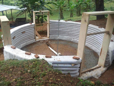 An earthbag roundhouse with frames ready for windows and doors earthbag3